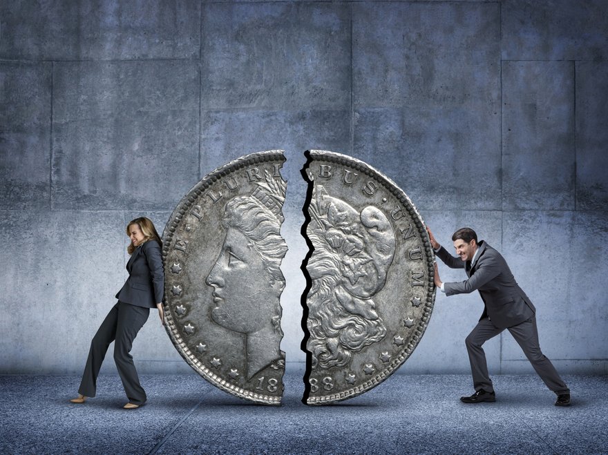 Woman and man pushing a coin split in half back together