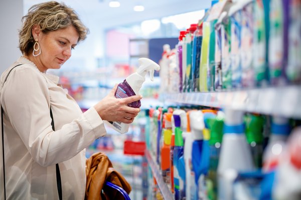 A person shopping for cleaning products in a supermarket.