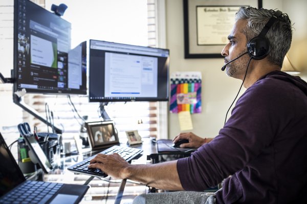 Person looking at multiple computer monitors.