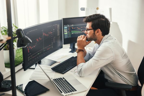 Person looks at graphs on computer.