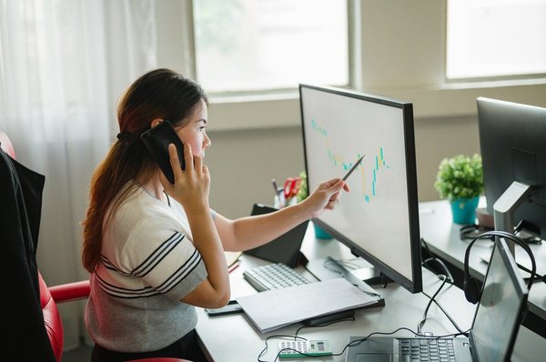 Person tracking stock prices on a computer screen.