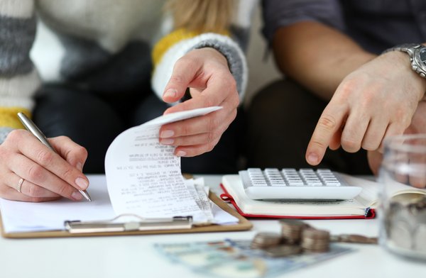 Two people working on calculator and writing notes.