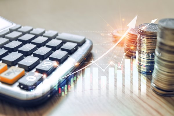 Stacks of coins next to a calculator and a chart showing an up arrow.